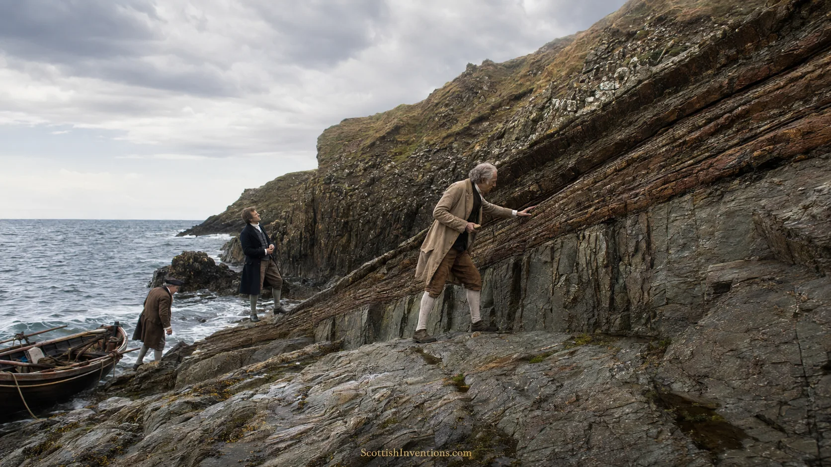 Historical reconstruction of James Hutton examining the angular unconformity at Siccar Point on the Scottish coast.